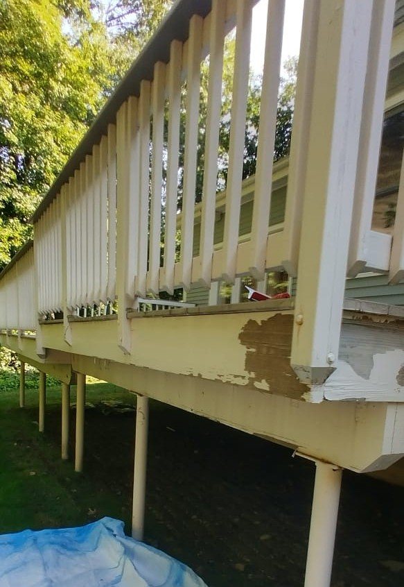 Deck railing before refinishing, showing peeling paint